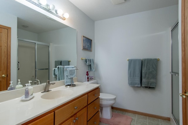 full bath with a stall shower, toilet, vanity, and baseboards