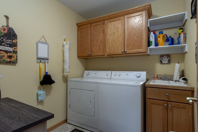 laundry room featuring cabinet space, a sink, washer and clothes dryer, and baseboards