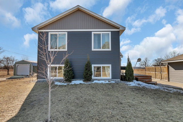 back of property with an outbuilding and fence