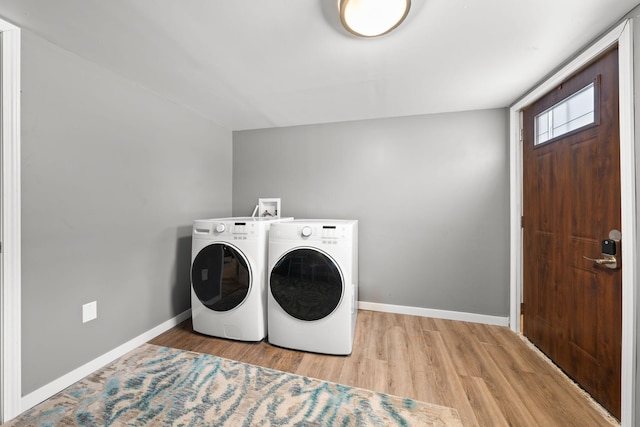 washroom with washer and dryer and light hardwood / wood-style flooring