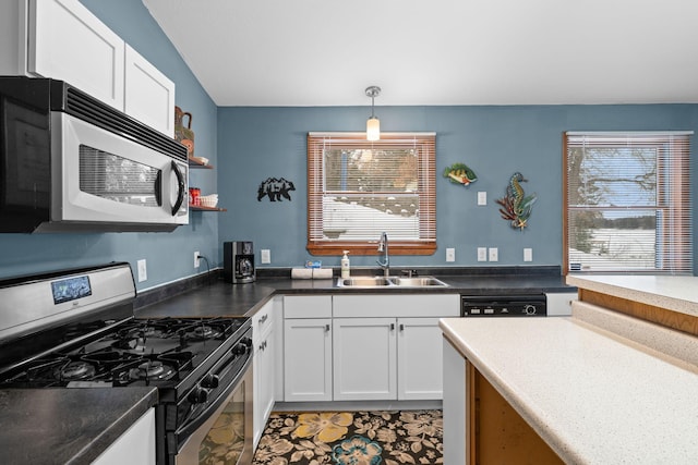 kitchen with pendant lighting, sink, white cabinets, and appliances with stainless steel finishes