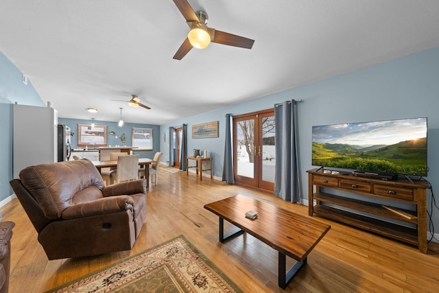 living room with light hardwood / wood-style floors, french doors, and ceiling fan