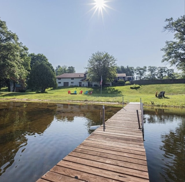 dock area with a water view and a lawn