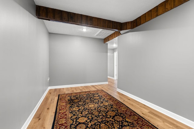 corridor featuring visible vents, light wood-style flooring, and baseboards