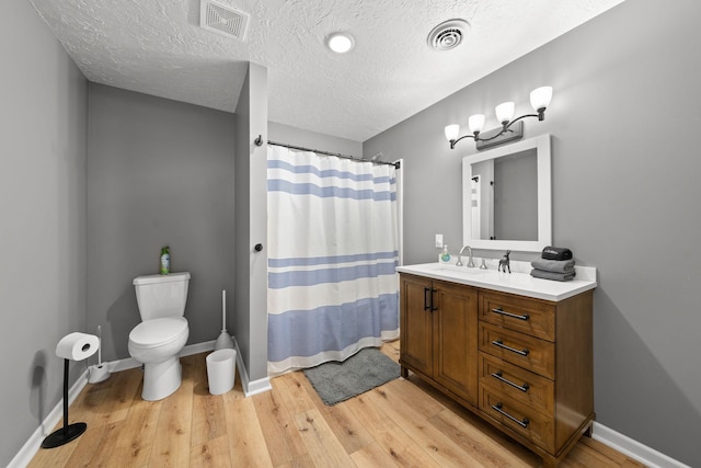 bathroom featuring toilet, hardwood / wood-style flooring, and visible vents