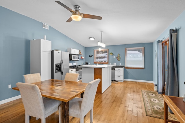 dining space featuring lofted ceiling, visible vents, light wood-style flooring, and baseboards