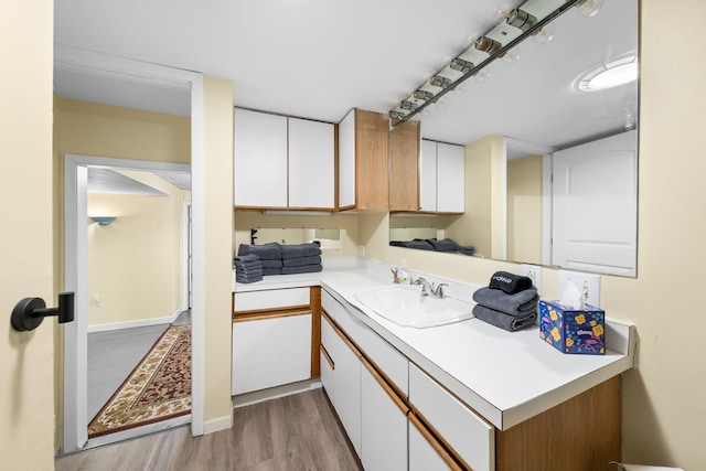 interior space with light countertops, light wood finished floors, a sink, and white cabinetry