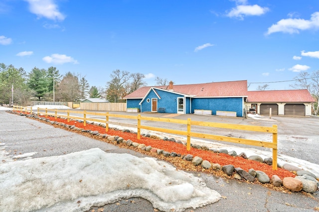 view of front of house with a fenced front yard, a detached garage, and stucco siding