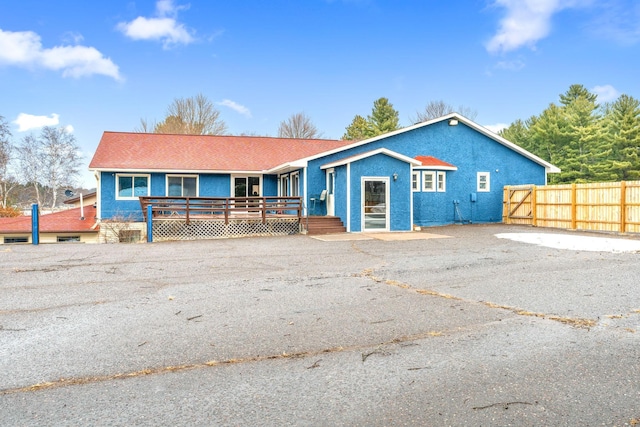 view of front of property featuring fence and stucco siding