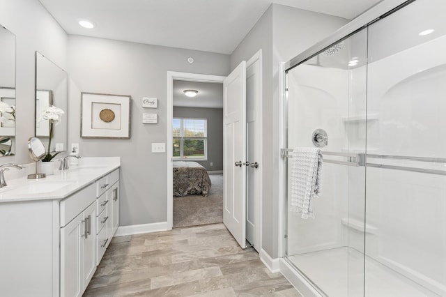 bathroom featuring vanity and a shower with door