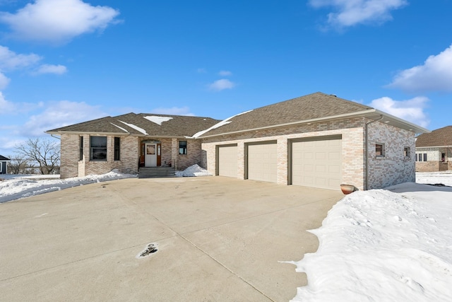 view of front of house with an attached garage, brick siding, driveway, and a shingled roof
