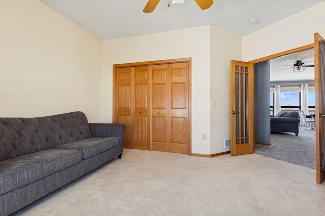 living room with carpet flooring, baseboards, and ceiling fan