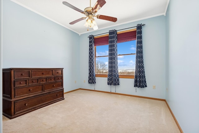 unfurnished bedroom with ceiling fan, baseboards, light colored carpet, and ornamental molding