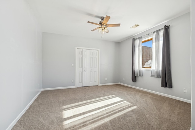 unfurnished bedroom with visible vents, carpet, baseboards, a closet, and a ceiling fan