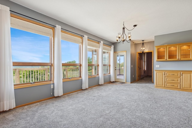 531 Depree Way, Glenwood, MN 56334 - kitchen with carpet, a chandelier, glass insert cabinets, baseboards, and pendant lighting