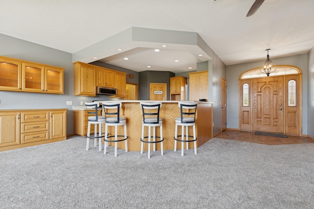 531 Depree Way, Glenwood, MN 56334 - kitchen with stainless steel microwave, carpet floors, a breakfast bar area, recessed lighting, and a ceiling fan