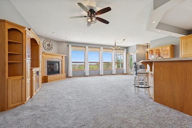 531 Depree Way, Glenwood, MN 56334 - unfurnished living room with carpet floors, a chandelier, a tile fireplace, ceiling fan, and recessed lighting