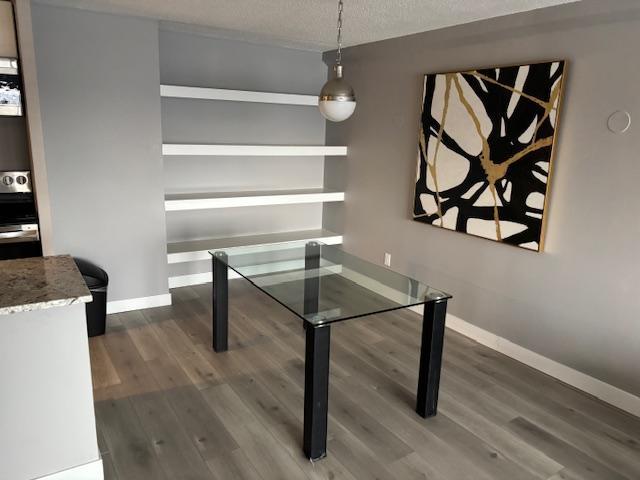 dining space featuring dark hardwood / wood-style floors and a textured ceiling