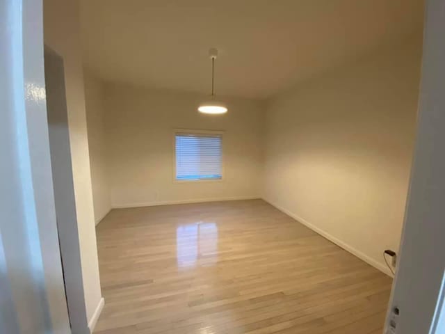 empty room featuring light wood-style flooring and baseboards