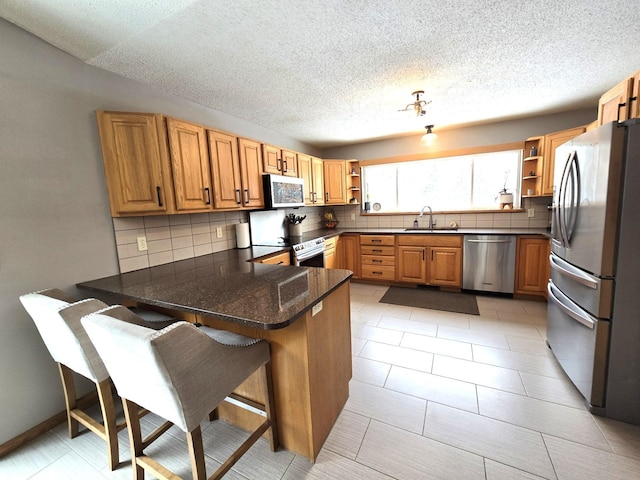 kitchen with open shelves, a peninsula, stainless steel appliances, and a kitchen breakfast bar