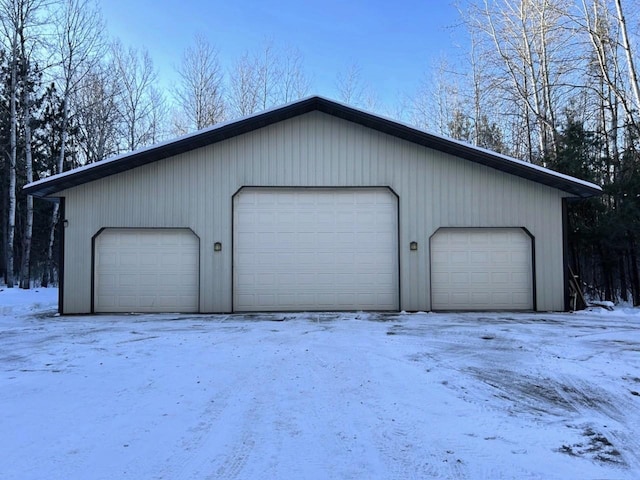 snow covered garage with a garage