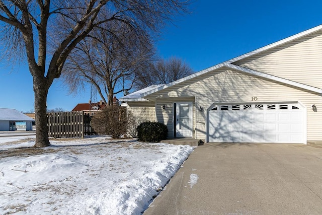 snow covered property with a garage