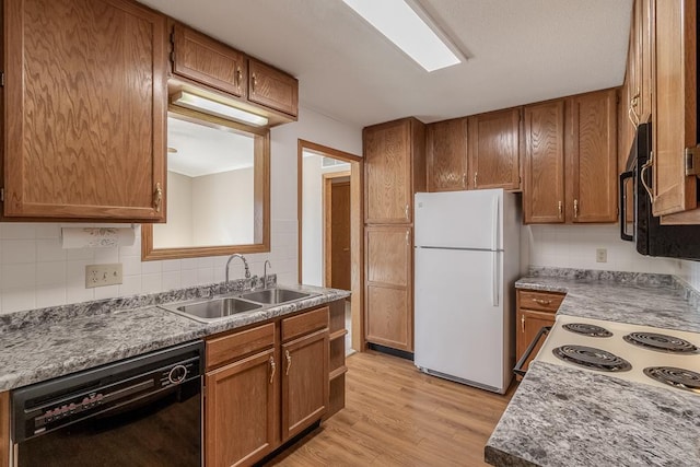 kitchen with sink, tasteful backsplash, light hardwood / wood-style flooring, white refrigerator, and black dishwasher