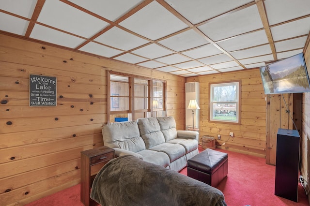 living room with coffered ceiling, carpet flooring, and wood walls