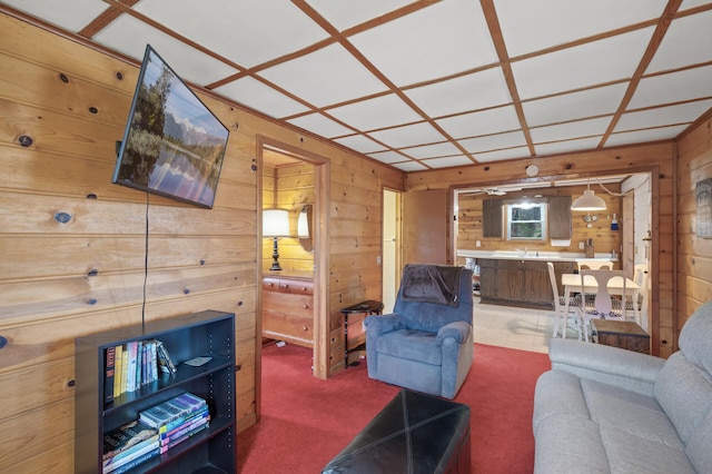 carpeted living room featuring coffered ceiling and wooden walls