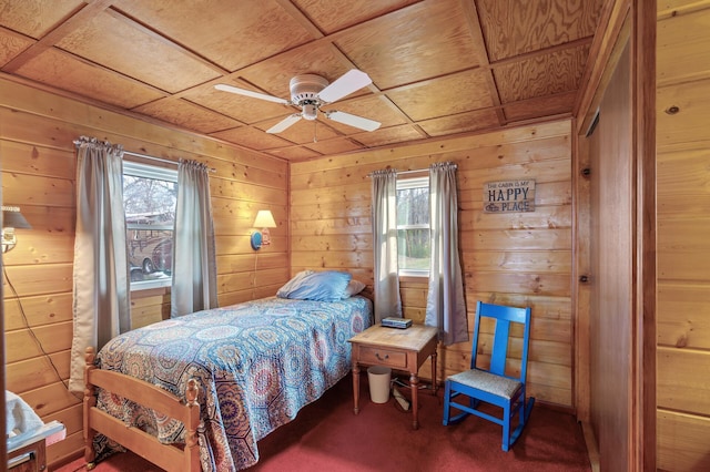 carpeted bedroom featuring wood walls