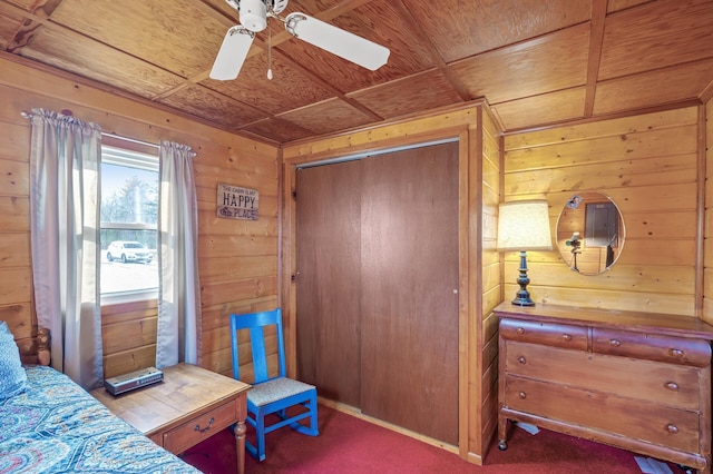 bedroom with carpet floors, wooden walls, wooden ceiling, and a closet