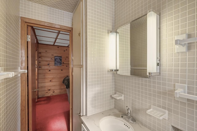 bathroom featuring vanity and tile walls