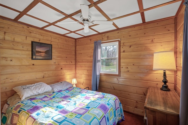 bedroom with coffered ceiling, ceiling fan, and wood walls