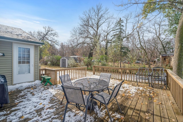 snow covered deck featuring a storage unit