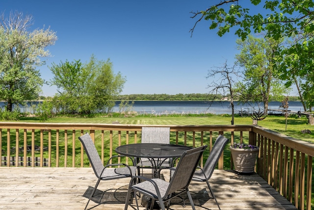 wooden terrace with a water view and outdoor dining area