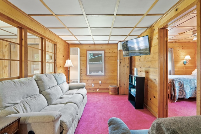 carpeted living area with wood walls
