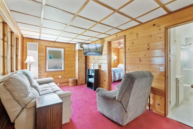 living area with wood walls and carpet flooring