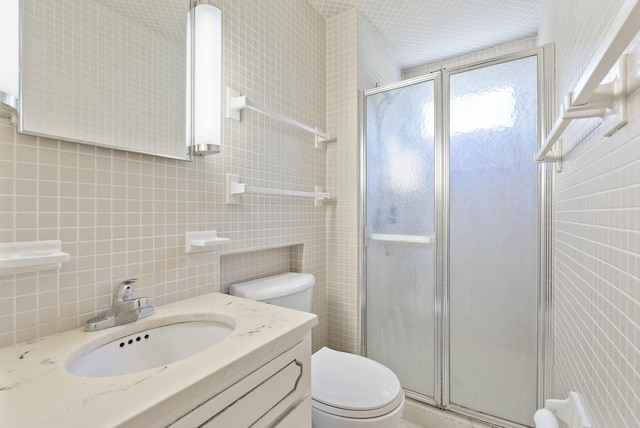 full bathroom featuring tile walls, toilet, a shower stall, vanity, and tasteful backsplash