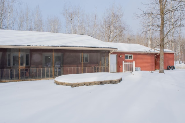 view of snow covered back of property