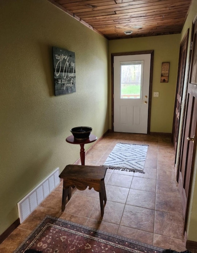 doorway with wood ceiling, a textured wall, light tile patterned floors, and visible vents