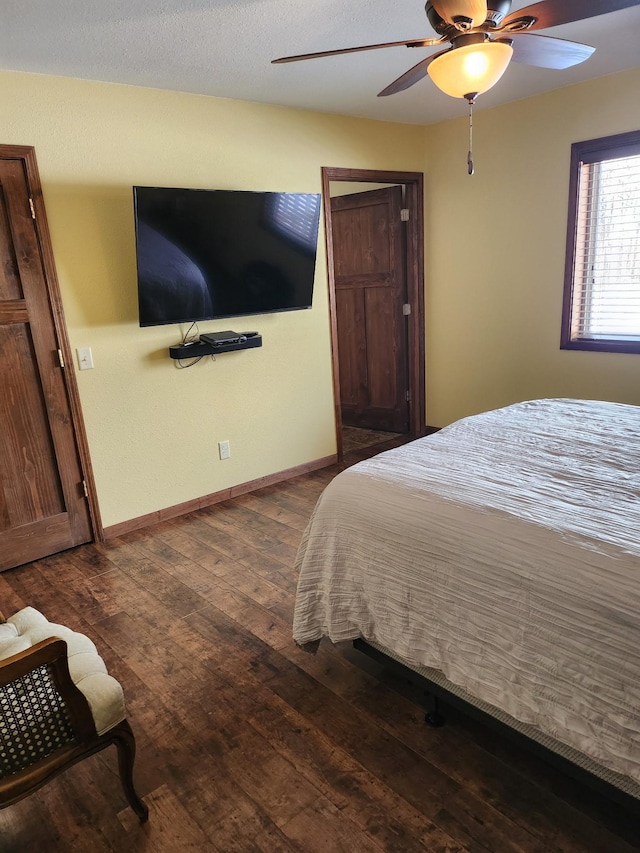 bedroom featuring ceiling fan, dark wood-type flooring, and baseboards