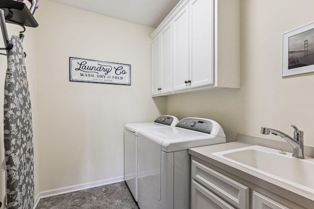 laundry area with a sink, washing machine and clothes dryer, cabinet space, and baseboards