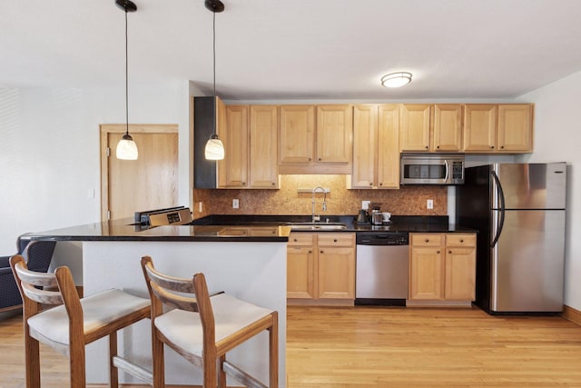 2701 Harriet Ave Unit 200, Minneapolis, MN 55408 - kitchen with stainless steel appliances, a sink, light brown cabinets, and dark countertops