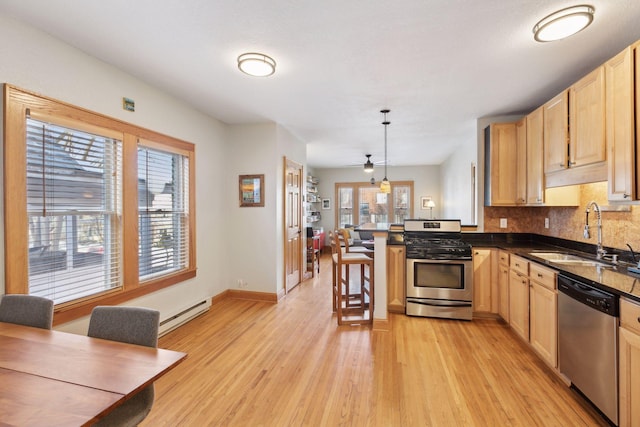 2701 Harriet Ave Unit 200, Minneapolis, MN 55408 - kitchen featuring stainless steel appliances, a sink, a peninsula, and light brown cabinetry