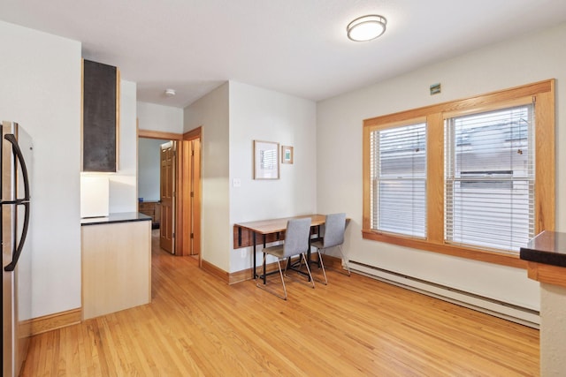 2701 Harriet Ave Unit 200, Minneapolis, MN 55408 - dining area with a baseboard heating unit, light wood-style flooring, and baseboards