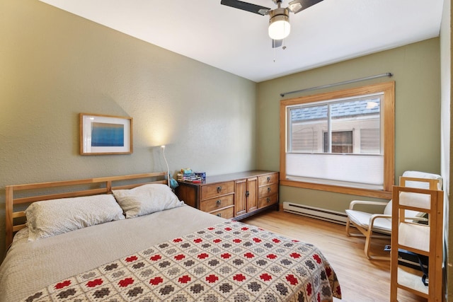 2701 Harriet Ave Unit 200, Minneapolis, MN 55408 - bedroom featuring a baseboard heating unit, light wood-type flooring, and ceiling fan