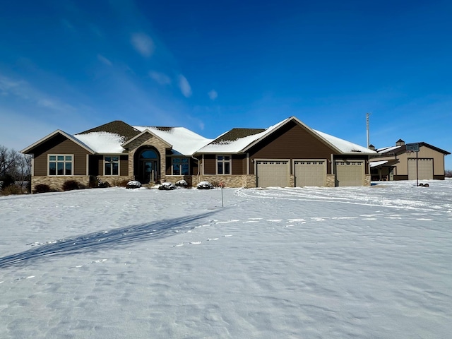 ranch-style home featuring stone siding and an attached garage