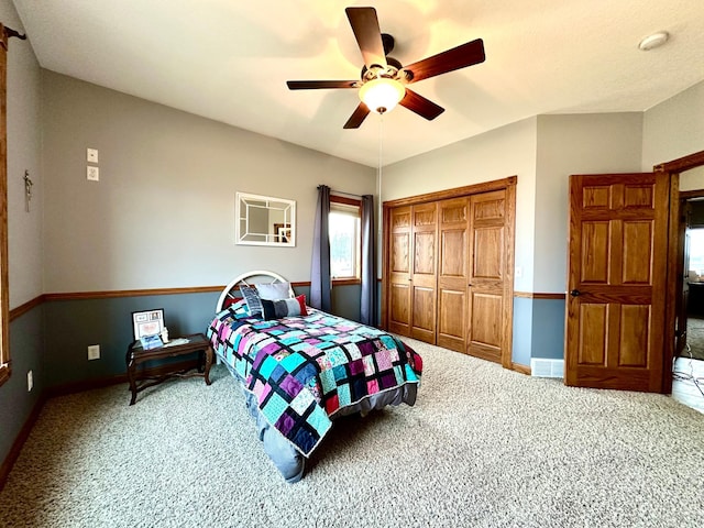 carpeted bedroom featuring ceiling fan, a closet, and baseboards