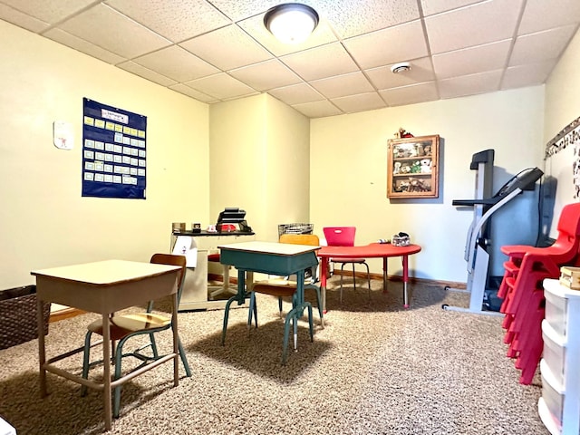 recreation room featuring baseboards and a drop ceiling