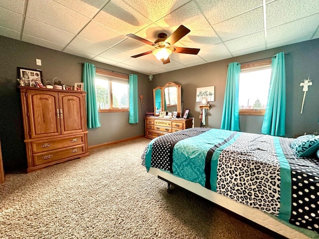 bedroom featuring a ceiling fan, a paneled ceiling, light colored carpet, and baseboards